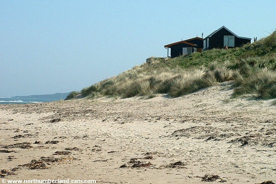 View at the south end of the beach with holiday homes on the dunes above.